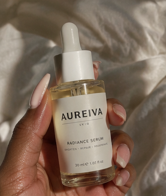 Aureiva serum held against cream linen